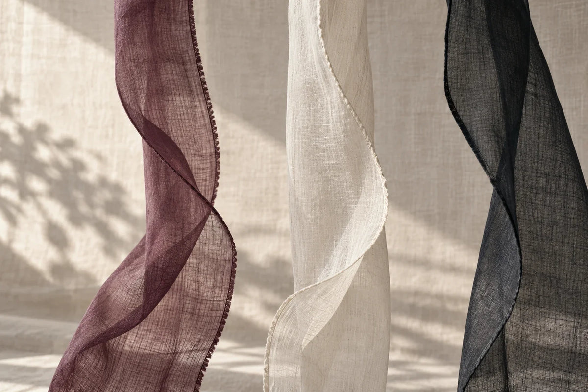 Suspended narrow textile edges in plum, ivory and ink